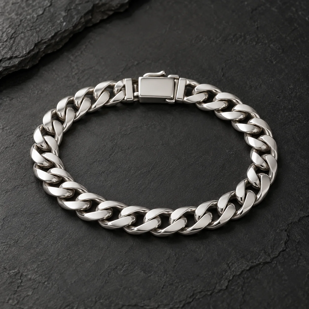 Polished silver Cuban link bracelet on a dark surface
